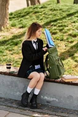 Şık bir üniforma içindeki genç bir yetişkin güzel bir günde dışarıda ders çalışabilir..