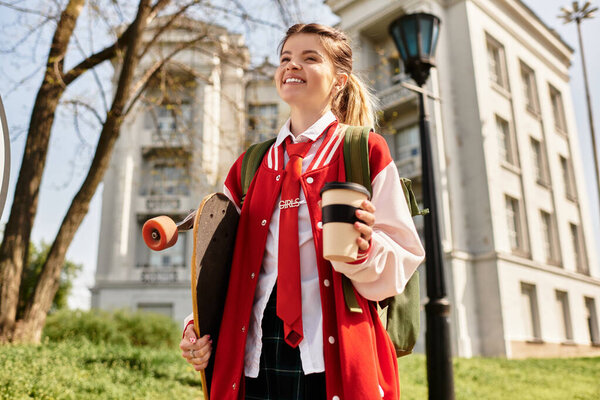 In a vibrant campus setting, a young adult radiates joy carrying a skateboard and coffee.