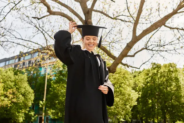 Parlak gülümsemeler, mezuniyet elbisesi ve şapkası giyen genç bir yetişkini süslüyor, doğadaki başarıyı kutluyor..