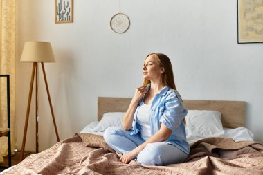 Genç bir kadın yatağında huzur içinde oturup evinde dinleniyor..