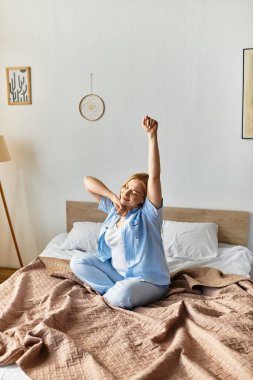 Parlak ve neşeli genç kadın, sıcak yatak odasında mutluluk ve sıcaklık saçarak uzanıyor..