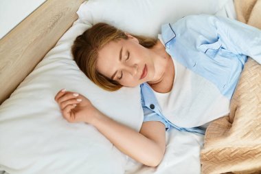 Genç bir kadın rahat yatak odasında huzur içinde uyuyor. Huzur ve rahatlık saçıyor..