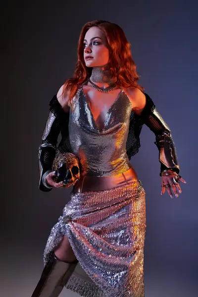 Genç bir kadın zarif bir şekilde Castle core modasından esinlenerek gümüş bir elbise içinde poz veriyor..