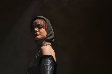 Genç, güzel bir kadın, atmosferik bir arkaplan karşısında çarpıcı bir kale merkezi kıyafeti sergiliyor..