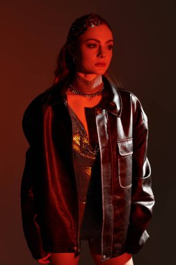 Genç bir kadın, güzelliğini ve tarzını yaratıcı bir arkaplanda zarif bir şekilde sergiliyor..