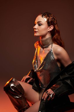 Genç bir kadın zarif ve özgüvenli bir şekilde modern kale kıyafetine ışık saçıyor..