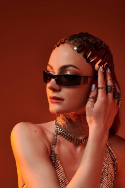 Güzel bir kadın lüks aksesuarlar ve şık kıyafetlerle süslenmiş zarif tarzını sergiliyor..