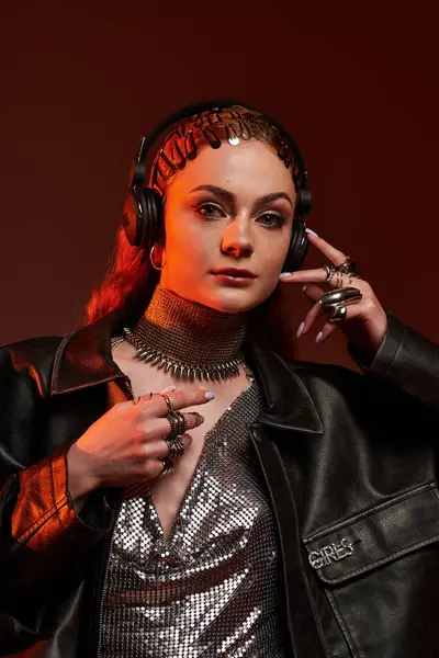 Şaşaalı kıyafetler ve kulaklıklar takan zarif bir kadın güven yayar..