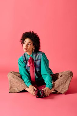 Genç bir kadın, cazibesini ve tarzını sergileyen pembe bir zemine zarif bir şekilde poz verir..