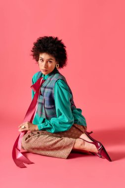 Genç ve güzel bir kadın pembe bir arka planda zarif bir şekilde poz veriyor..