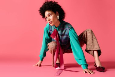 Genç bir kadın şık giyinerek dinamik bir poz veriyor, kendine güven ve tarz yayıyor..