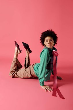 Genç bir kadın zarif bir şekilde modern moda sergiliyor ve neşeyle karnının üstünde yatıyor..