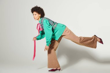 Yaratıcı bir stüdyo ortamında, genç bir kadın dinamik bir poz verir..