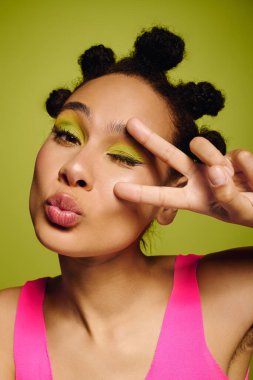 Parlak yeşil arkaplan zarif genç bayanı coşkuyla poz verirken tamamlıyor..