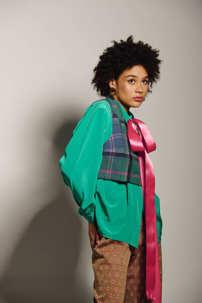 Уверенная молодая женщина в стильном, красочном наряде с элегантными деталями.