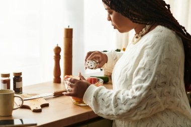 Parlak bir mutfakta, genç bir kadın ustalıkla taze malzemeli bir salata hazırlar..