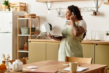 Genç bir kadın, karşılama alanında uzaktan çalışırken birden fazla iş yapıyor..