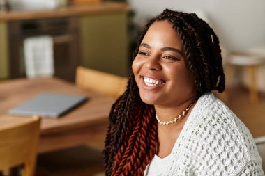 Genç bir Afrikalı Amerikalı kadın evinde dinleniyor, sakin sabahının ve neşeli anlarının tadını çıkarıyor..