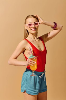 Parlak ve neşeli kadın renkli bir içecekle poz veriyor, yaz havası ve moda yayıyor..