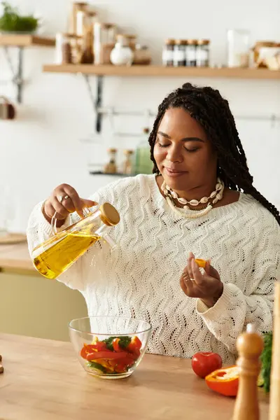 Genç bir Afrikalı Amerikalı kadın rahat evinde salata malzemelerini ustalıkla hazırlıyor..