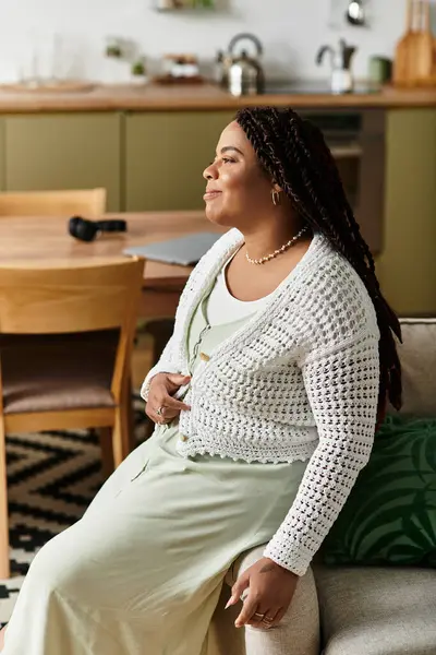 Genç bir Afrikalı Amerikalı kadın evinde dinleniyor, sakin bir sabah anından zevk alıyor..