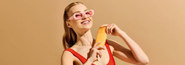 Genç bir kadın, elinde parlak bir aksesuarla pastel renklerin sıcak zeminine neşe saçıyor.