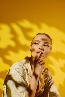 Çarpıcı özellikleri olan genç bir kadın neşeli bir ifadeyle gölgelerin arasında düşüncelere dalıyor..