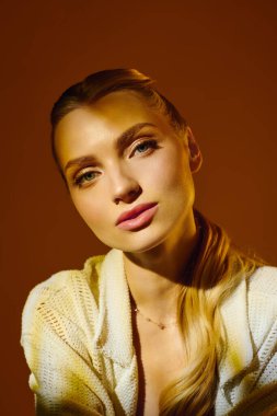 Büyüleyici genç kadın zarif bir şekilde poz veriyor, güzelliğini ve zarif tonlarını sergiliyor..