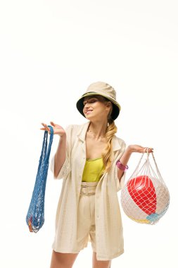 Şık bir genç kadın kumsal kıyafetlerini ve eğlenceli aksesuarlarını sergiliyor..