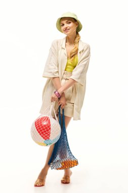 Şık bir kadın güneşli bir günü kucaklarken canlı torbalar tutar, kendine güven ve neşe saçar..