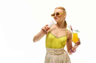 Genç bir kadın kendinden emin bir şekilde renkli kokteyllerle poz veriyor, canlı yaz tarzıyla hava atıyor..