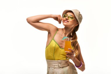 Çekici genç bir kadın, neşeli bir şekilde poz veriyor, neşe saçıyor ve moda yaz modası havası yayıyor..