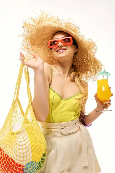 Genç bir kadın renkli bir içecek ve moda yaz modayla güneşin altında poz veriyor..