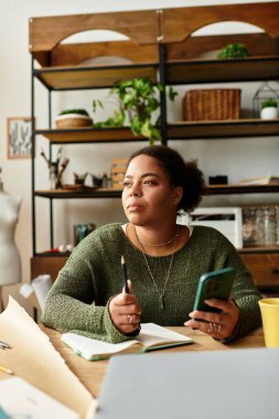 Bir kadın, bir sonraki yaratıcı projesini rahat bir atölyede düşünürken el işi yapar..
