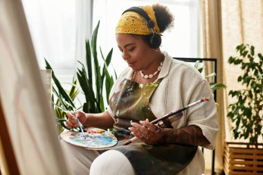 Güzel bir kadın ustalıkla resim yapar, yaratıcılığı palette gelişir..