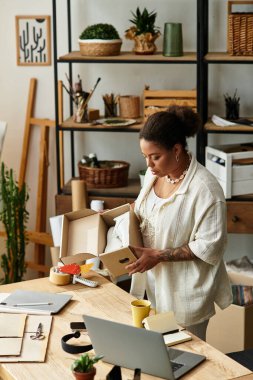 Güzel bir kadın, yoğun ve yaratıcı bir atölyede malzeme kutuları açıyor..