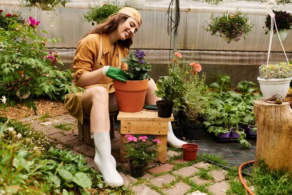 Neşeli, genç bir bahçıvan huzurlu seradaki çiçekleriyle ilgilenir..