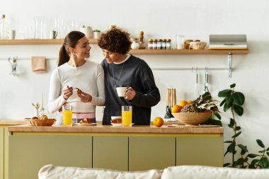 Neşeli çift, güneşli bir kahvaltı saatinde evde tatlı ikramları ve sohbetleri paylaşıyor..