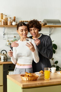 Sevgi dolu çiftler mutfaklarında sarılır, kahvaltıdan zevk alır ve telefonda neşeli bir gülümseme paylaşırlar..