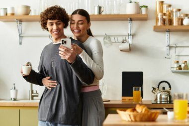 Sevgi dolu bir çift, sıcaklıkla çevrili aydınlık mutfaklarında selfie çekerken kahkahalardan zevk alır..