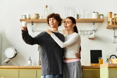 Sıcak bir mutfakta, neşeli bir çift içkilerini yudumlarken sevgi dolu bir anı paylaşır..