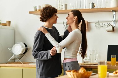 Sıcak bir mutfakta içki yudumlarken iki insan birbirine eşlik ediyor..