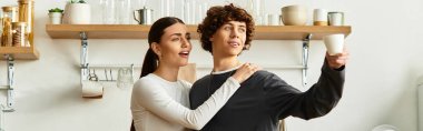 Mutlu bir çift sıcak mutfaklarında durur, gülümser ve neşeli bir anın tadını çıkarırlar..