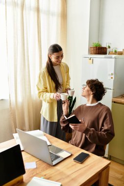Sevgi dolu bir çift, parlak bir mutfakta kahve içerken birbirlerine eşlik etmekten zevk alır.