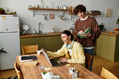 İki ortak, biri dizüstü bilgisayarda çalışırken diğeri kitap okurken aynı kaliteli zamanı paylaşır..