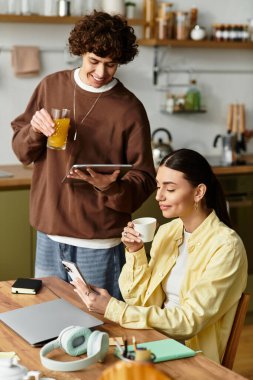 Bir çift evde keyifli bir anı paylaşıyor, birlikte rahatlarken gülümsüyor ve içkinin tadını çıkarıyor..