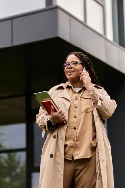 Modern bir akademik binanın önünde tablet konuşmalarıyla üniversite eğitimcisi.