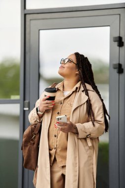 Bir üniversite eğitimcisi düşünceli bir şekilde başını kaldırıp kahvenin tadını çıkarırken ara verir..