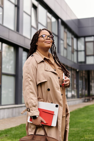 University educator enjoying a moment of reflection outdoors while holding teaching materials.