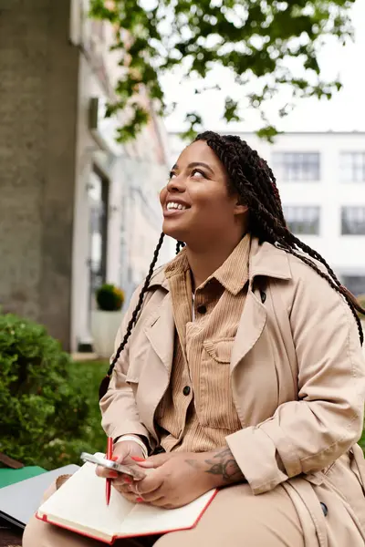 Korkunç bir üniversite öğretmeni dışarıda oturuyor, gülümsüyor, bir defterle derin düşünceler içinde..